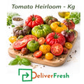 Fresh heirloom tomatoes sold per kilogram, mixed variety tomatoes on cutting board